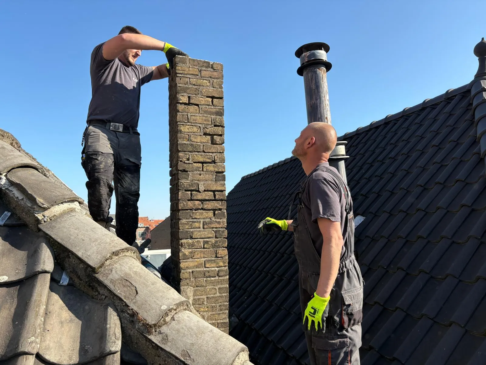 Gemetselde schoorsteen wordt hersteld, steen voor steen opnieuw opgebouwd